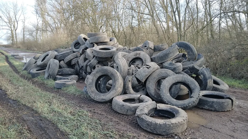 Mound of tyres dumped by the river in Whittlesey