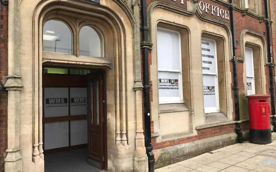 The former Post Office building which dates to the 19th century has a three-storey frontage to Bridge Street and side elevation facing Post Office Lane which lies to the east.