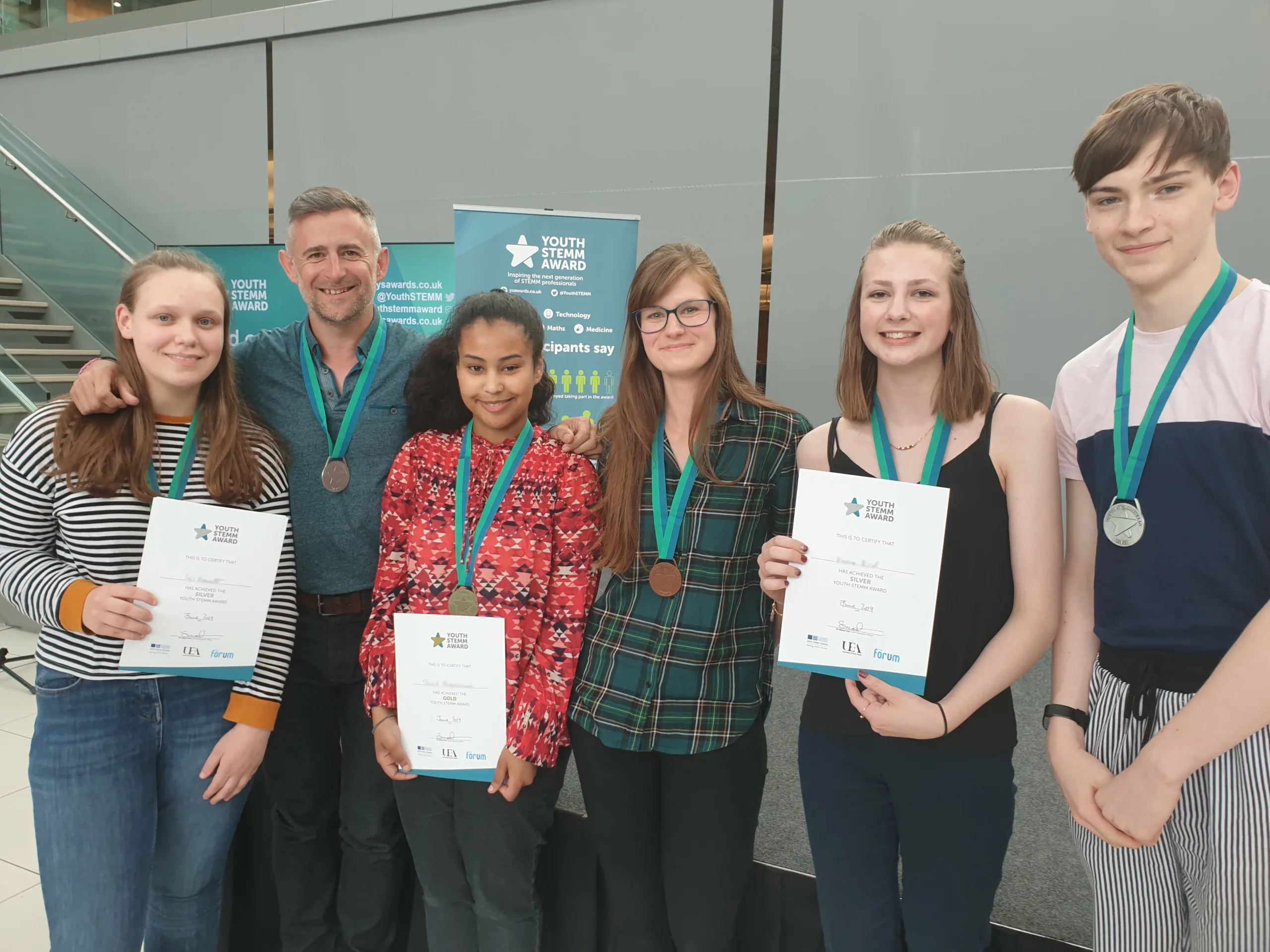 Image caption: Young people receiving their Youth STEMM Award medal from YSA ambassador Mark Thompson (BBC Stargazing Live broadcaster and author). Image credit: John Innes Centre.