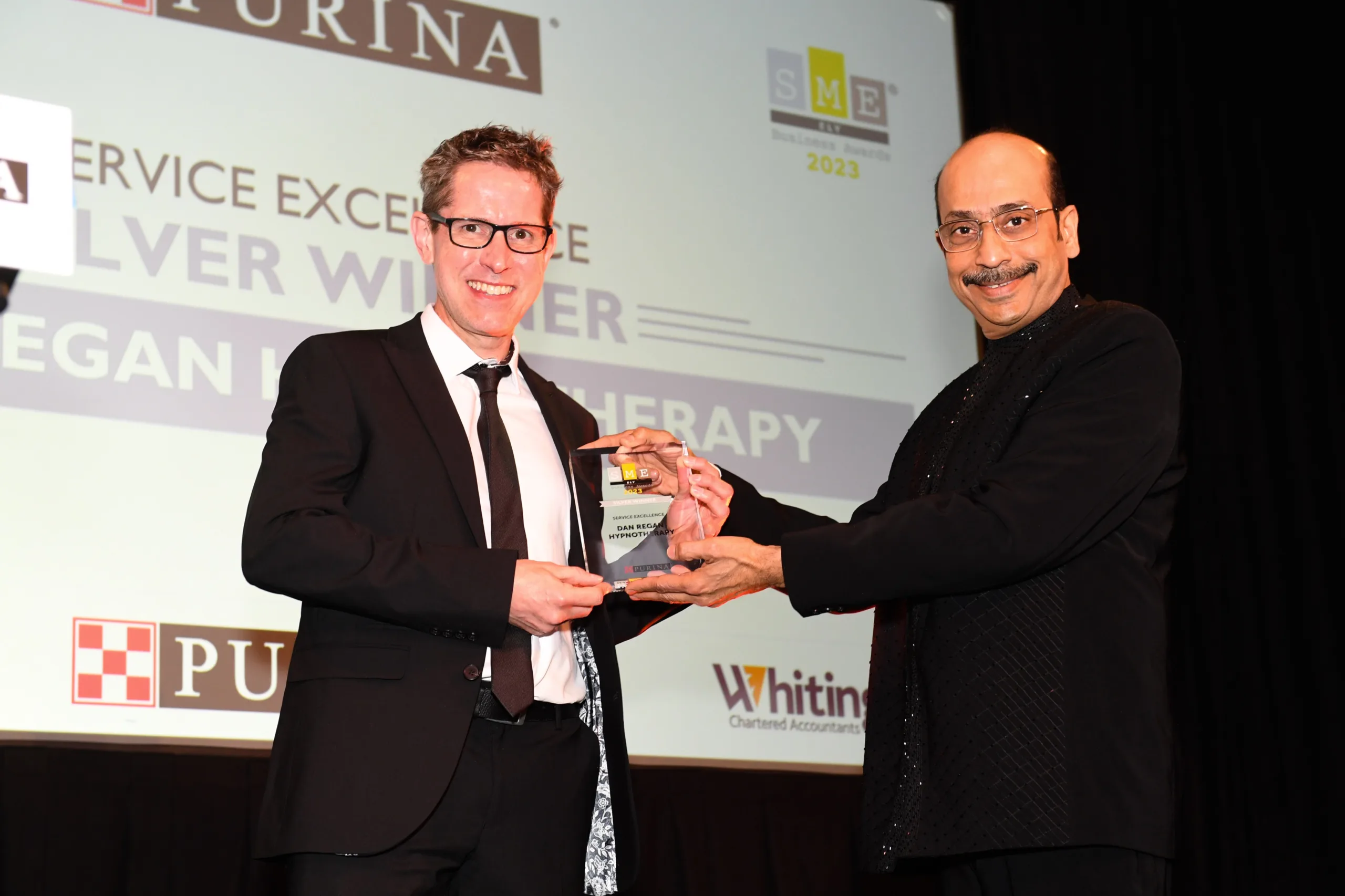 Dan Regan was presented with his latest award by Jamadagni Khandige from headline sponsors Nestle Purina. PHOTO: SME Ely Business Awards).