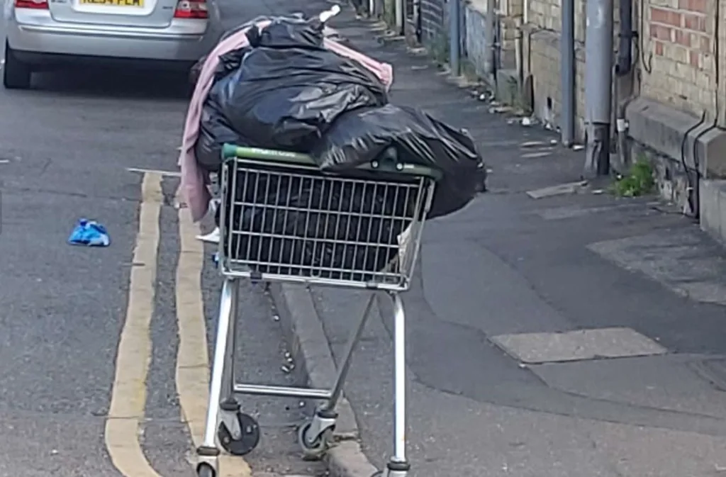 FixMyStreet upload from resident and the accompany comment: Rubbish dumped in trolley left in front of Cromwell Rd/ Cobden Ave