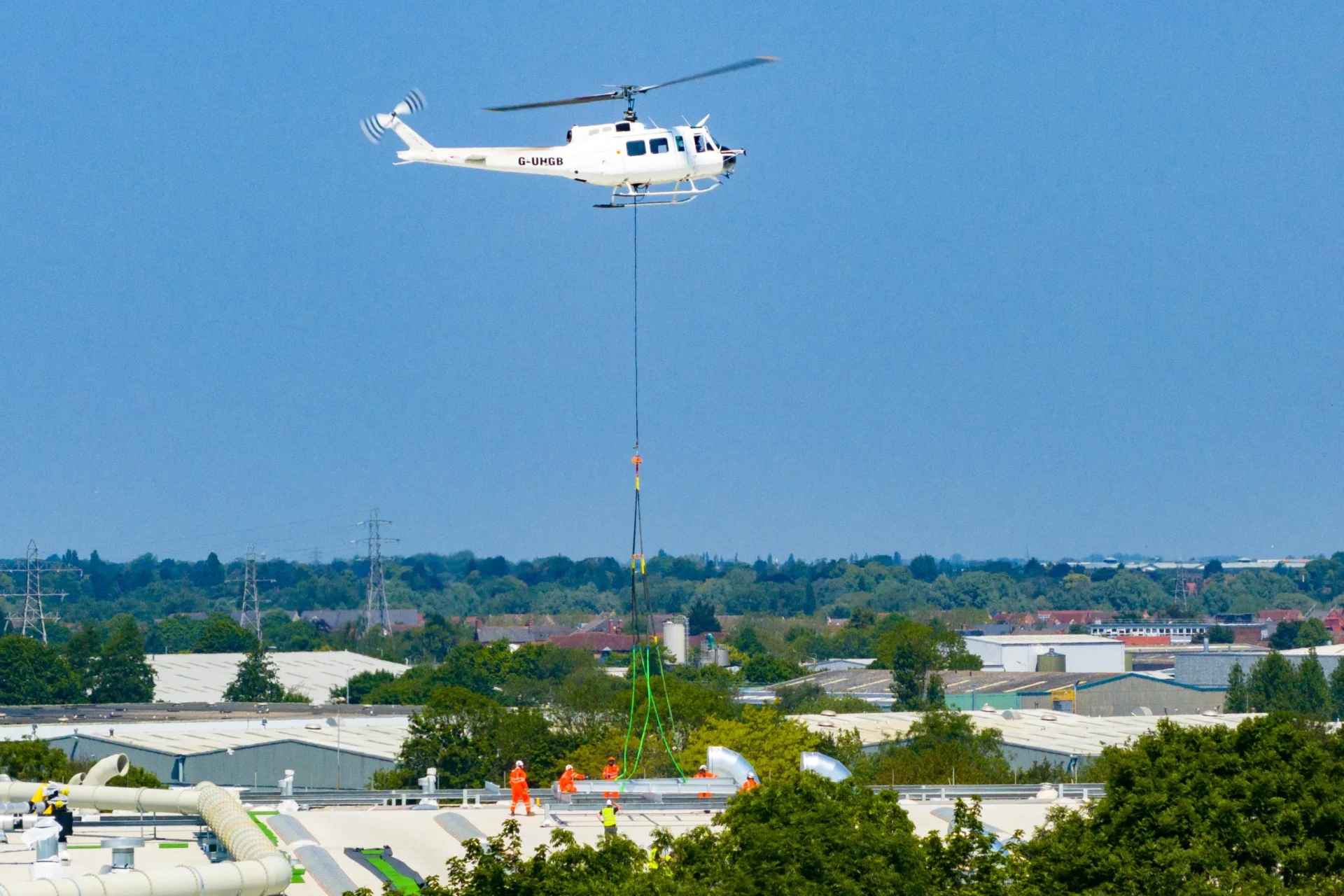 A 625,000ft sq ft factory complex under construction in Peterborough is using a Bell 205A-1 Helicopter (Helilift Services) to move construction materials to the roof of the massive factory., Delta Park, Peterborough Saturday 10 June 2023. Picture by Terry Harris.