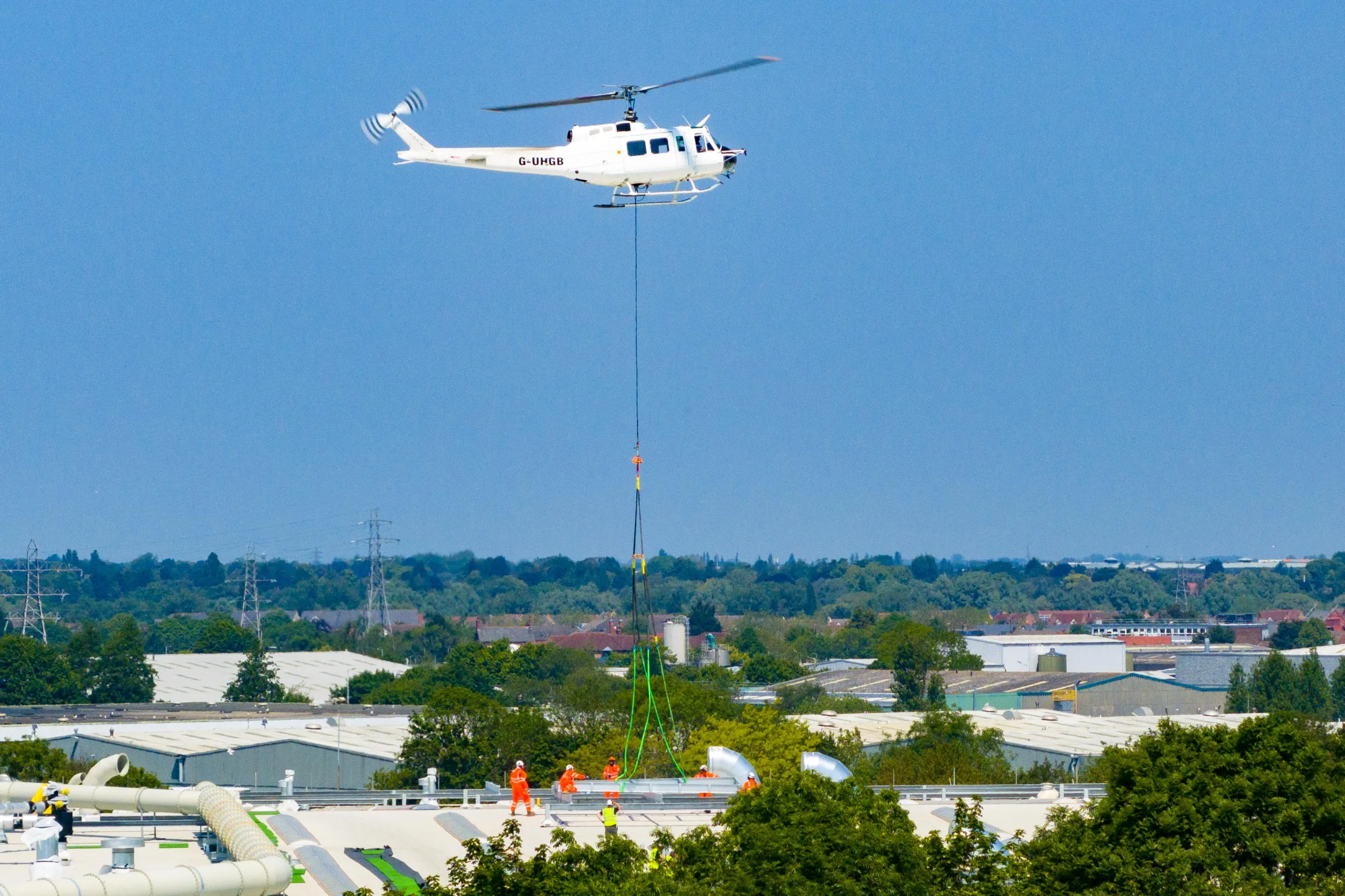 A 625,000ft sq ft factory complex under construction in Peterborough is using a Bell 205A-1 Helicopter (Helilift Services) to move construction materials to the roof of the massive factory., Delta Park, Peterborough Saturday 10 June 2023. Picture by Terry Harris.
