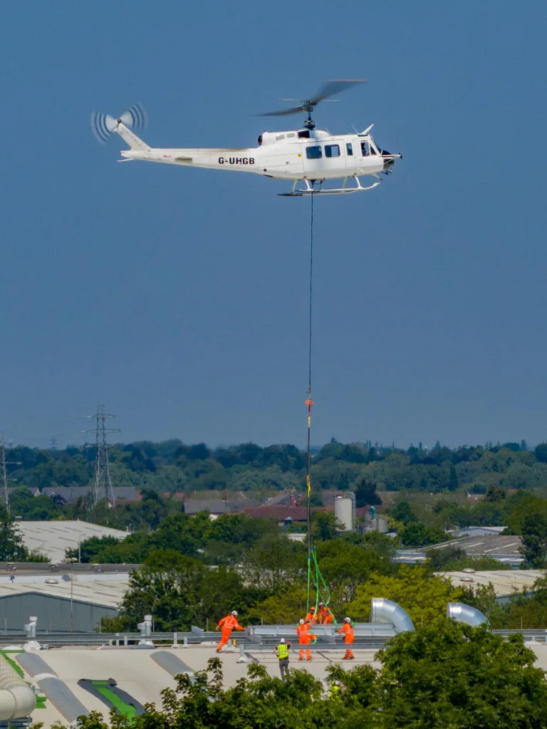 A 625,000ft sq ft factory complex under construction in Peterborough is using a Bell 205A-1 Helicopter (Helilift Services) to move construction materials to the roof of the massive factory.,Delta Park, Peterborough
Saturday 10 June 2023. 
Picture by Terry Harris.