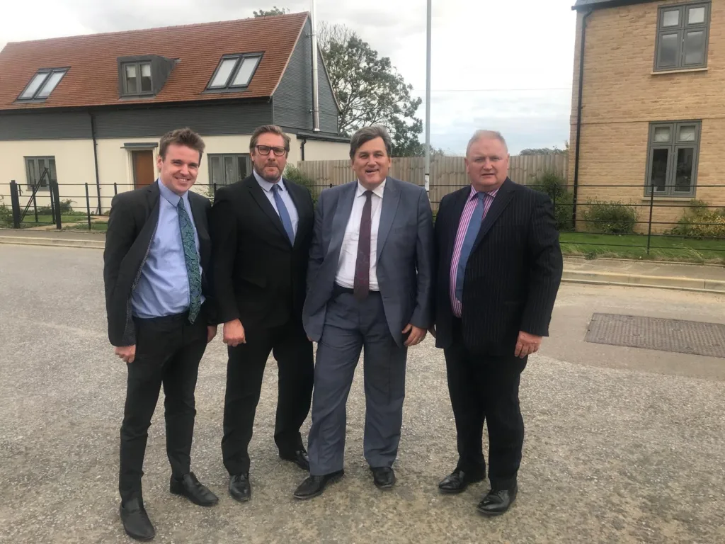 Charles Roberts (right) tweeted back in 2018 that it “was a pleasure to show the Housing Minister Kit Malthouse (2nd right) around Stretham CLT earlier this week. He commented upon the fantastic design of the homes and the “entrepreneurial” approach taken by East Cambs Council”. With them is former Mayor James Palmer and former Cllr Tom Hunt, now MP for Ipswich. 
