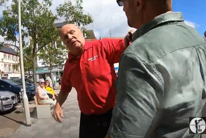 CAPTION This was the moment a stall holder lost his cool – and ‘cooled down’ a street preacher by throwing a bucket of water over him. Police have launched an inquiry. 