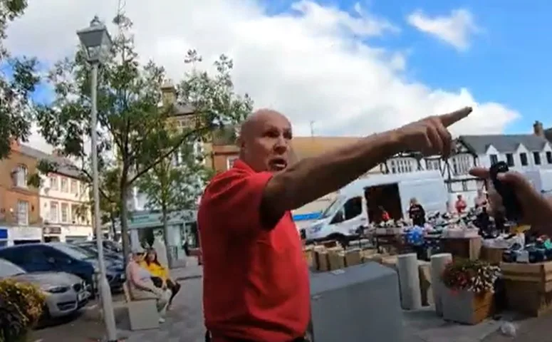 CAPTION This was the moment a stall holder lost his cool – and ‘cooled down’ a street preacher by throwing a bucket of water over him. Police have launched an inquiry. 