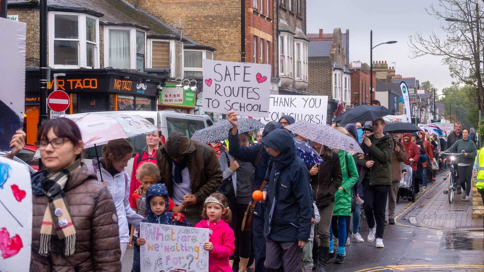 Cambridge UK. 21st October 2023. Local residents take part in a 1970’s themed dance and march along Mill Road to demand the introduction of a bus gate to restrict traffic flows in the city street. Credit: Alex Brown Hundreds turn out to campaign for traffic restrictions that residents say will improve immeasurably life in the Mill Road area of Cambridge