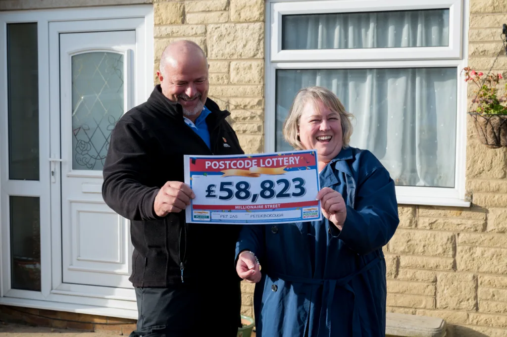Winner Melissa Setchfield receives her cheque alongside husband John