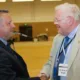 Sir Graham Bright (right) congratulating his successor Jason Ablewhite as police and crime commissioner for Cambridgeshire PHOTO: Terry Harris