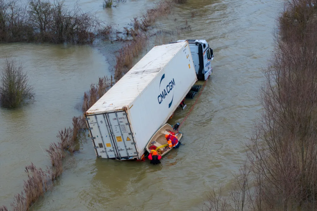 Manchetts staff weighing up the options to rescue lorry and container from flooded A1101 at Welney on the Cambridgeshire/Norfolk border. PHOTO: Terry Harris 