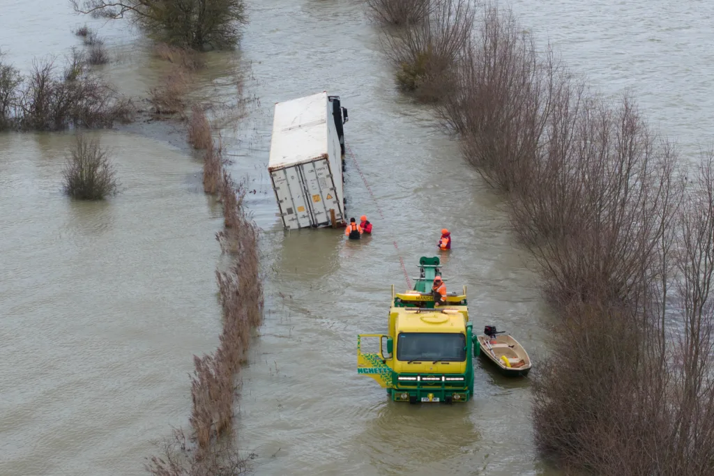 Manchetts staff weighing up the options to rescue lorry and container from flooded A1101 at Welney on the Cambridgeshire/Norfolk border. PHOTO: Terry Harris 