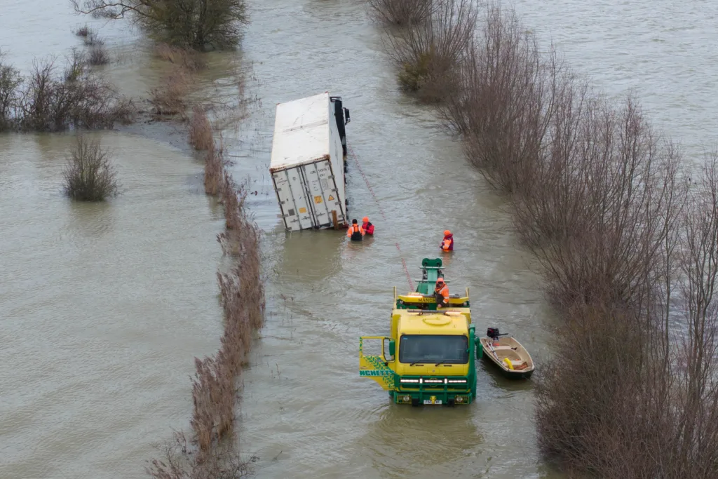 Manchetts staff weighing up the options to rescue lorry and container from flooded A1101 at Welney on the Cambridgeshire/Norfolk border. PHOTO: Terry Harris
