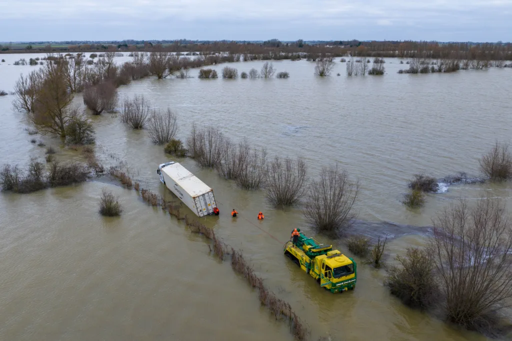 Manchetts staff weighing up the options to rescue lorry and container from flooded A1101 at Welney on the Cambridgeshire/Norfolk border. PHOTO: Terry Harris 