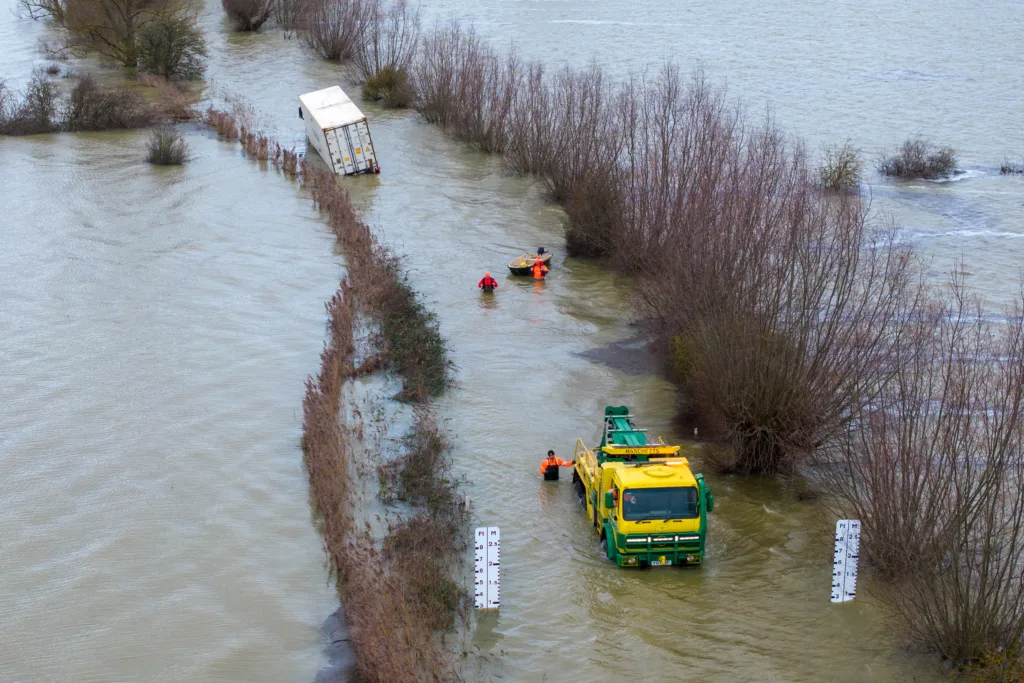 Manchetts staff weighing up the options to rescue lorry and container from flooded A1101 at Welney on the Cambridgeshire/Norfolk border. PHOTO: Terry Harris 