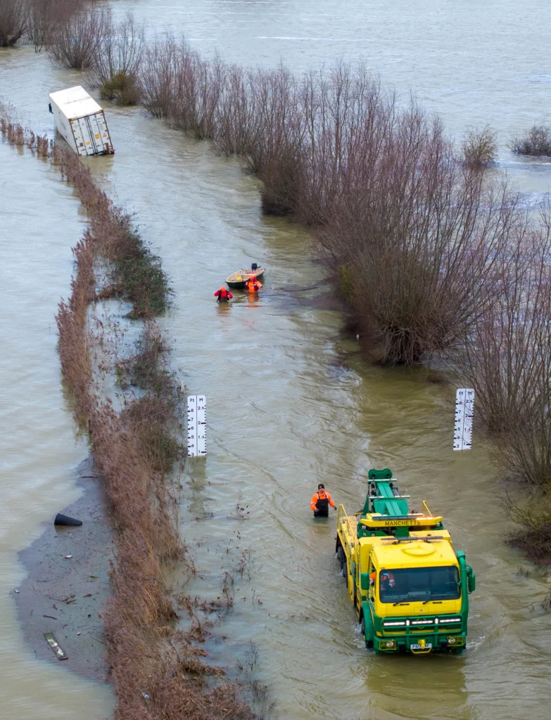 Manchetts staff weighing up the options to rescue lorry and container from flooded A1101 at Welney on the Cambridgeshire/Norfolk border. PHOTO: Terry Harris 