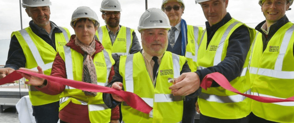 Press release from Peterborough City Council: “The end of April 2022 marked an important construction milestone at our Hilton Garden Inn Peterborough City Centre. A topping-out ceremony was enjoyed by our team and leaders of the Peterborough City Council to celebrate the completion of the roof, glazing and flooring installation in the Sky Bar, and signage now being visible from the exterior of the building.”