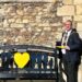 covid 1 - News for Peterborough and Cambridgeshire News for Peterborough and Cambridgeshire - Mayor of Huntingdon Cllr Karl Brockett tying a ribbon around the bench