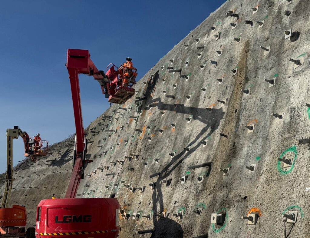 Plans remain on track to re-open the road fully by the end of February. Work continues on the final layer of sprayed concrete, focused on the top of the embankment to allow traffic management to be removed as planned on 28 February. IMAGE: Cambridgeshire County Council