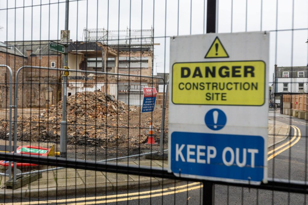 Exclusive CambsNews photos show the aftermath of demolition of the former Barclays Bank in March: a vast, fenced-off hole on Broad Street, next to the war memorial, where a landmark building once stood. PHOTO: Terry Harris