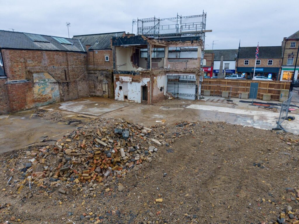 Exclusive CambsNews photos show the aftermath of demolition of the former Barclays Bank in March: a vast, fenced-off hole on Broad Street, next to the war memorial, where a landmark building once stood. PHOTO: Terry Harris