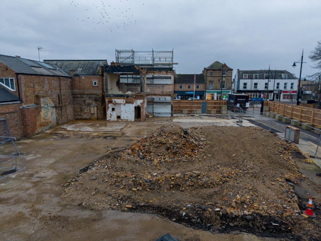 Exclusive CambsNews photos show the aftermath of demolition of the former Barclays Bank in March: a vast, fenced-off hole on Broad Street, next to the war memorial, where a landmark building once stood. PHOTO: Terry Harris