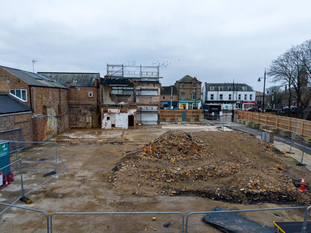 Exclusive CambsNews photos show the aftermath of demolition of the former Barclays Bank in March: a vast, fenced-off hole on Broad Street, next to the war memorial, where a landmark building once stood. PHOTO: Terry Harris