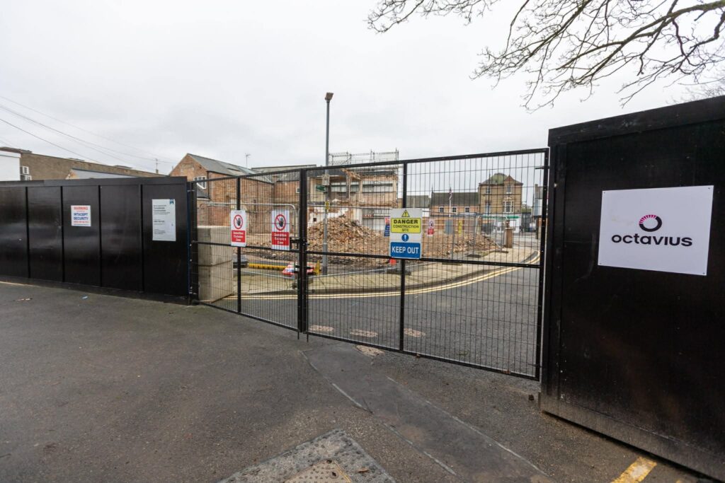 Exclusive CambsNews photos show the aftermath of demolition of the former Barclays Bank in March: a vast, fenced-off hole on Broad Street, next to the war memorial, where a landmark building once stood. PHOTO: Terry Harris