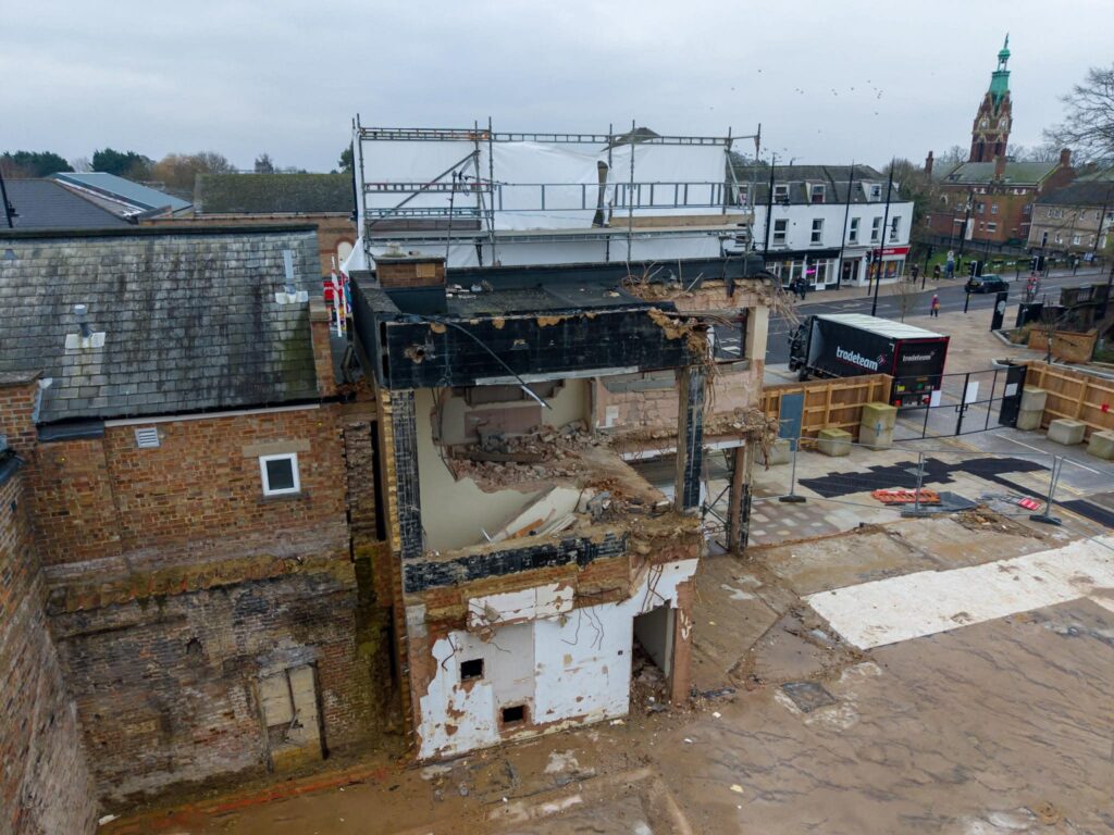 Exclusive CambsNews photos show the aftermath of demolition of the former Barclays Bank in March: a vast, fenced-off hole on Broad Street, next to the war memorial, where a landmark building once stood. PHOTO: Terry Harris