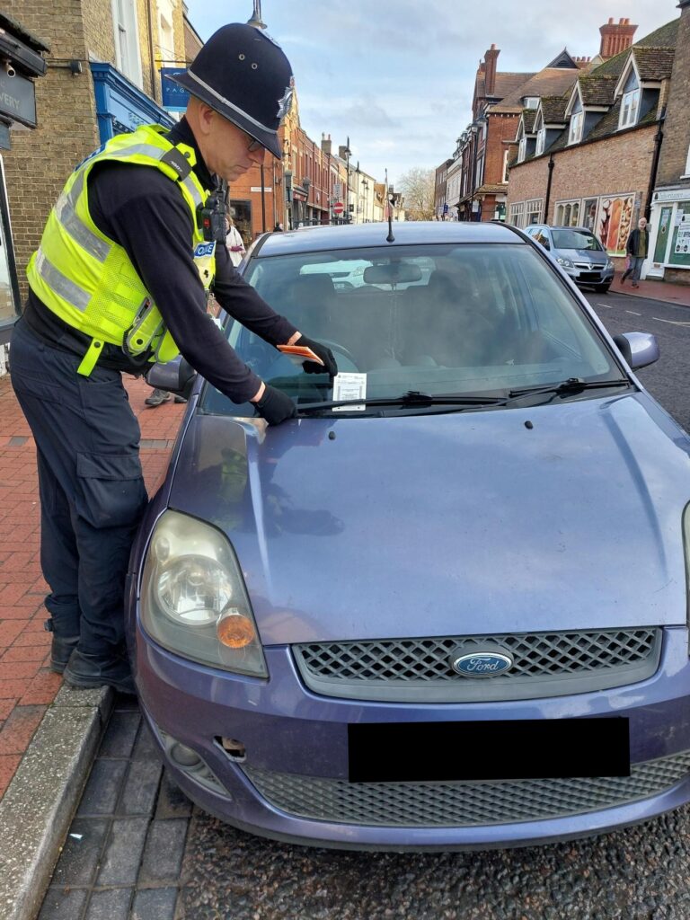Police officers issue parking tickets during a targeted enforcement operation in Ely, highlighting the continued reliance on limited police resources in the absence of civil parking enforcement across East Cambridgeshire. PHOTO: Policing East Cambridgeshire
