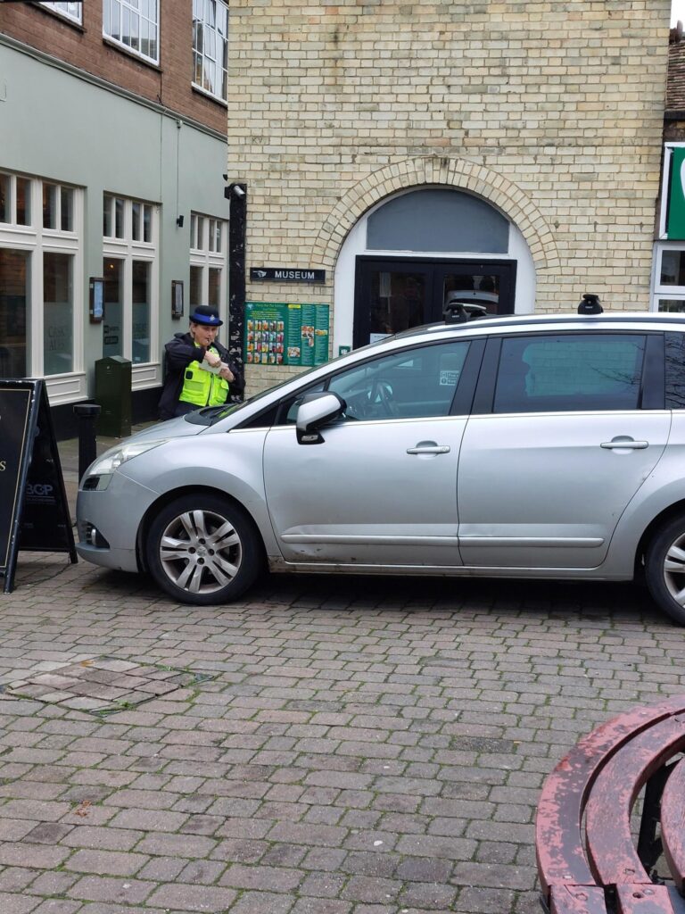 Police officers issue parking tickets during a targeted enforcement operation in Ely, highlighting the continued reliance on limited police resources in the absence of civil parking enforcement across East Cambridgeshire. PHOTO: Policing East Cambridgeshire