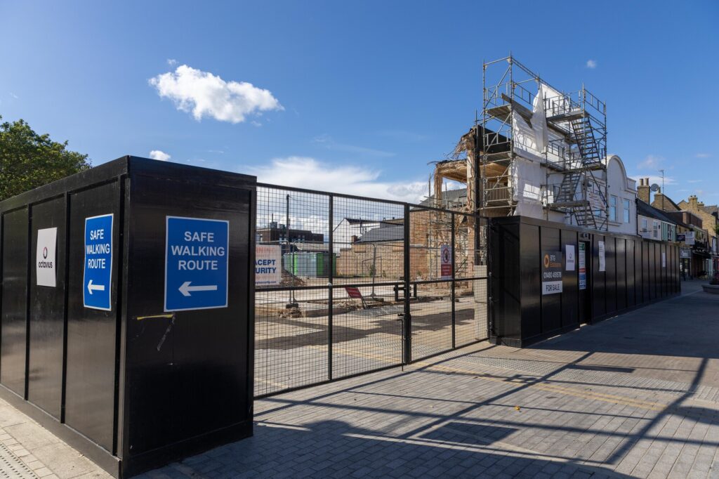 The partially demolished former Barclays Bank building remains fenced off in Broad Street amid ongoing party wall issues which have halted full clearance of the site. Photo: Terry Harris/CambsNews