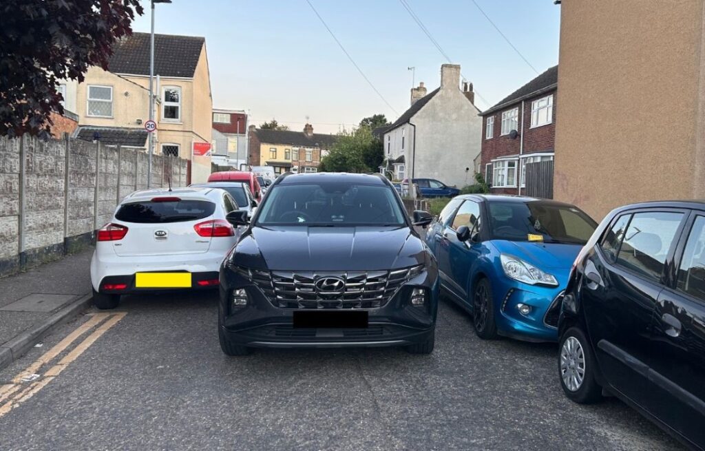 A Cambridgeshire Fire and Rescue Service emergency vehicle squeezes between tightly parked cars on Victoria Street in Fletton while crews respond to a house fire in Peterborough. PHOTO: Cambridgeshire Fire and Rescue