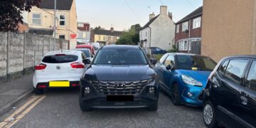A Cambridgeshire Fire and Rescue Service emergency vehicle squeezes between tightly parked cars on Victoria Street in Fletton while crews respond to a house fire in Peterborough. PHOTO: Cambridgeshire Fire and Rescue